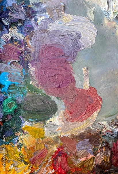 Fototapeta Close-up of an artist’s palette filled with mixed oil paints. Textured colors background. Vertical