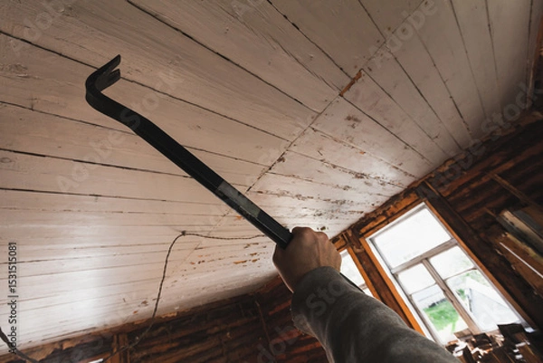 Obraz A hand gripping a crowbar in an indoor construction or renovation setting
