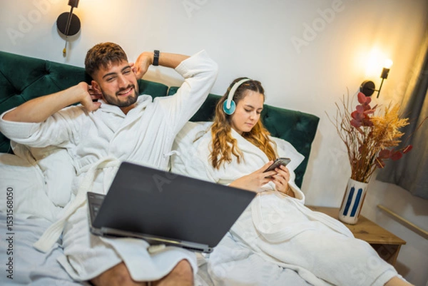 Fototapeta Modern Couple in Bed – Separate Digital Worlds, Shared Space