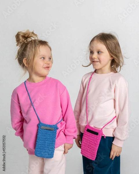 Obraz Two funny cute girls playing and having fun. Children with smiles and funny emotions on a light background. Vertical photo. High quality photo