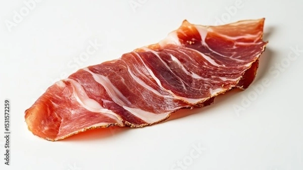 Fototapeta A single slice of cured ham with visible fat marbling on a white surface in a studio shot close up
