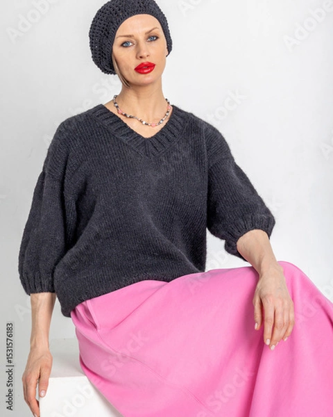 Obraz Beautiful woman in black jumper, pink skirt and black beret in French style. Bright makeup with red lipstick. Vertical photo. High quality photo