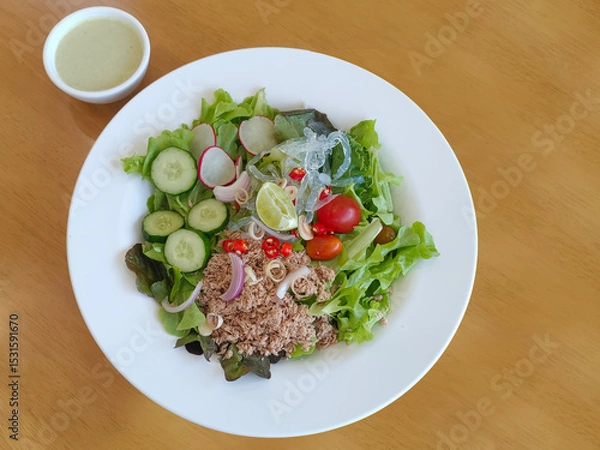 Fototapeta top view Tuna salad on a white plate and salad dressing in a cup on the table, food, vegetables, copy space