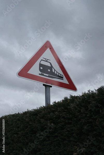 Fototapeta A red and white sign with a train on it is on a pole