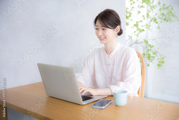 Fototapeta Smiling woman in front of computer Office casual image Cute woman in pink sheer shirt
