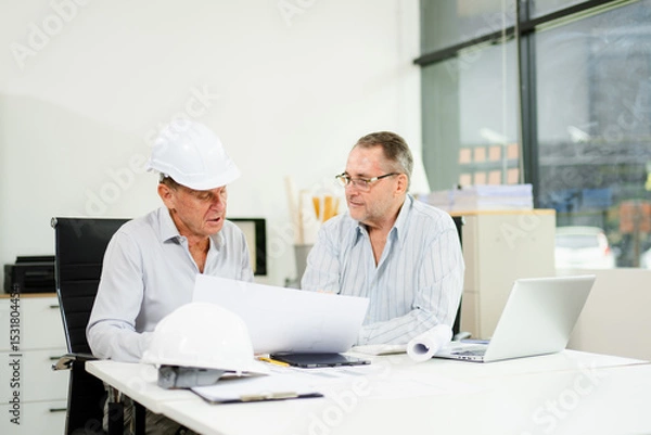 Fototapeta Engineers are discussing data working and laptop or tablet with architectural project at new construction site
