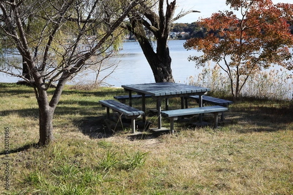 Obraz テーブルとベンチと紅葉のある湖畔風景　