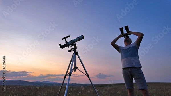 Fototapeta Amateur astronomer using telescope and binoculars for watching stars, Moon, planets and other celestial objects from a countryside field in nature.