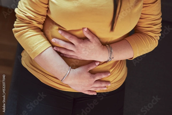 Fototapeta Woman with strong stomach ache, menstrual and digestive issues at home.