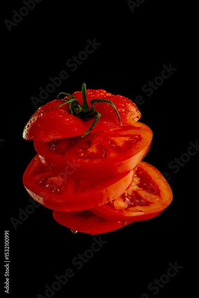 Obraz Juicy tomato cut into slices suspended in air with a kitchen knife. Fresh, dynamic concept of cooking and food preparation.