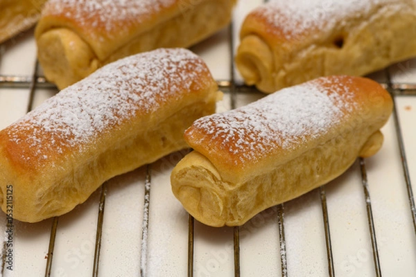 Obraz Golden homemade Parker House rolls resting on a wire rack after baking, fresh from the oven and ready to serve.
