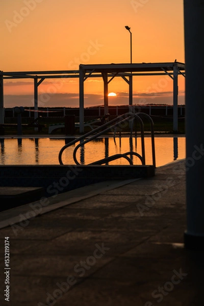 Obraz Still pool water reflecting dramatic sunset colors in a quiet residential complex on the Mediterranean island