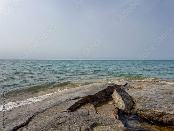 Obraz Rocky shore and clear water of Issyk-Kul under a vast sky