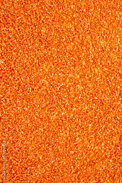 Fototapeta This is a detailed closeup view of a vibrant pile of orange glitter