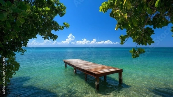 Fototapeta Serene Tropical Beach Scene Wooden Dock Extending into Crystal Clear Turquoise Ocean Waters under a Sunny Sky