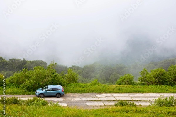Fototapeta perechyn, ukraine - 22 ju2 2019: 4wd car on a countryside mountain road. family suv for weekend on the hillside. mountain landscape of carpathian alps on a foggy morning in summer. vacation memories