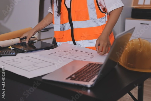 Fototapeta Closeup of team of industrial engineers meeting analyze machinery blueprints consult project on table in manufacturing factory. Working in manufacturing plant or production plant.