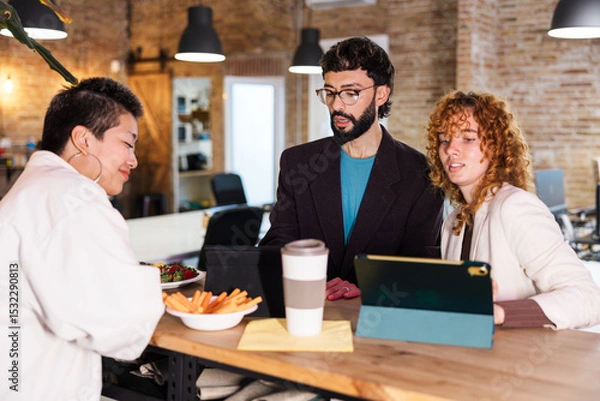 Fototapeta Colleagues collaborating during breaktime in modern office