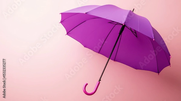 Fototapeta Purple umbrella floating on light pink background with curved handle, creating bright and cheerful atmosphere