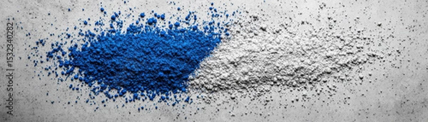 Fototapeta Blue and white powder pigment on gray surface with scattered particles creating vibrant and textured contrast
