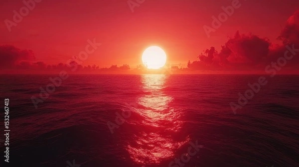 Fototapeta Red sunset over the ocean, small clouds around sun and reflections on water. Use this peaceful, romantic image for backgrounds or inspirational media.