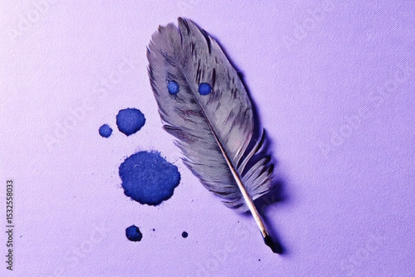 Fototapeta Single gray feather with blue ink drops on textured purple surface, creating calm and artistic composition with contrasting colors and delicate details