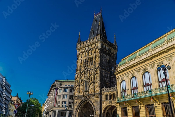 Fototapeta A view past ornate buildings towards the Powder Tower  in central Prague in springtime