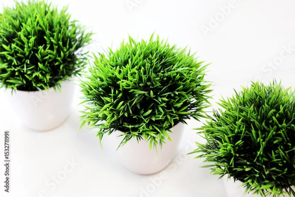 Fototapeta Three white pots with artificial grass. Grass for home decor.