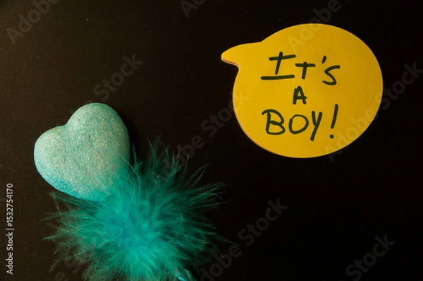 Fototapeta Photograph of a yellow emoji on a black background with  "It´s a boy "written inside.