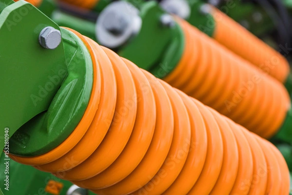 Obraz Orange hard spring made of steel. Part of big industrial or agricultural machine