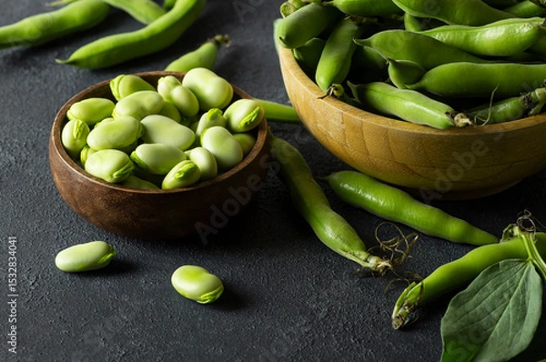 Fototapeta Fresh broad beans with pod in bowl on dark rustic background, healthy food