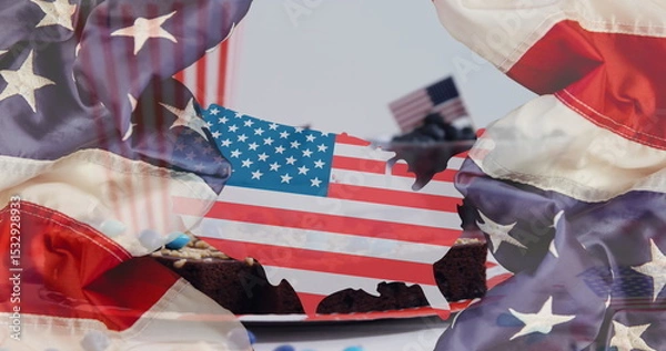 Fototapeta Displaying US flag cutout hovering over brownies with toothpick flags on table, with flag backdrop