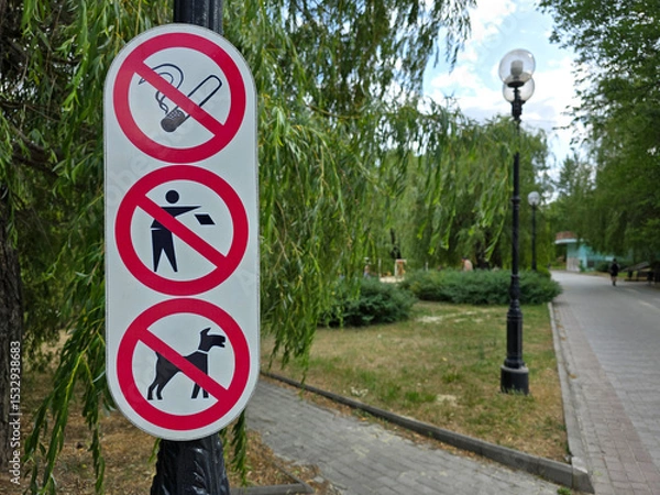 Fototapeta Informational notice no smoking, no littering, no dogs on a summer day in the park. Stop pollution. Protection of nature. Social rules