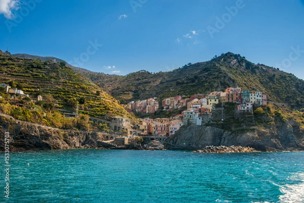 Fototapeta Monterosso al Mare, Cinque Terre, a seaside village with colorful buildings nestled between terraced cliffs above the blue waters of the Ligurian Sea.