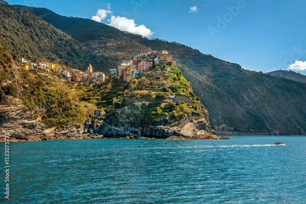 Fototapeta the cluster of colorful houses on the cliffs and terraced hills of Monterosso al Mare, Cinque Terre, a boat on the blue waters of the Mediterranean Sea.