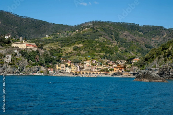 Fototapeta Monterosso al Mare, Cinque Terre, colorful buildings, fortress towers nestled between terraced cliffs above the blue waters of the Ligurian Sea.