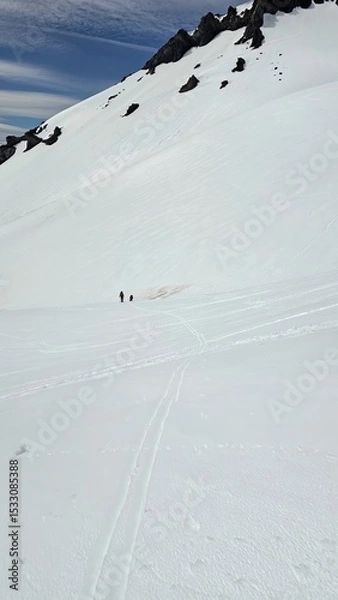 Obraz Two people standing on a vast snow covered landscape with mountain and sky in the background view