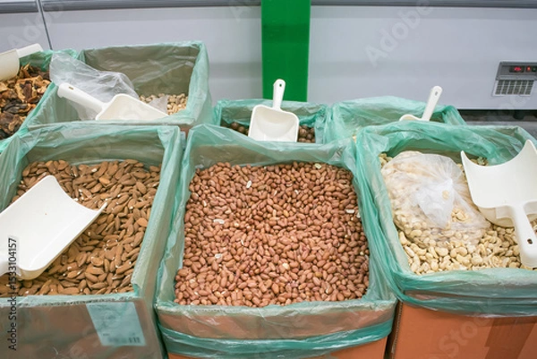 Fototapeta Bulk nuts and seeds displayed in bins at a market during daytime, showcasing a variety of healthy snacks in an organized setting