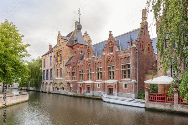 Fototapeta Historic architecture along a canal at dusk in summer. Bruges, Belgium.