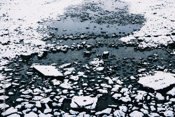 Obraz Snow covered rocks on the side of a river in New Zealand.