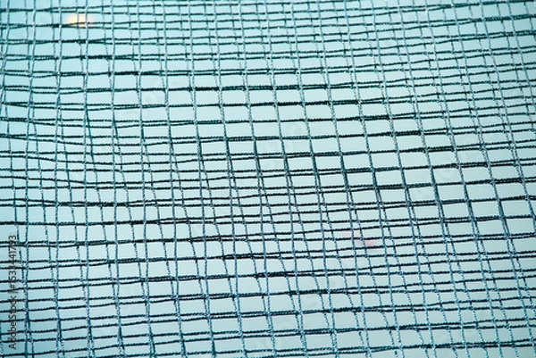 Fototapeta Black mesh string on blue water river abstract background