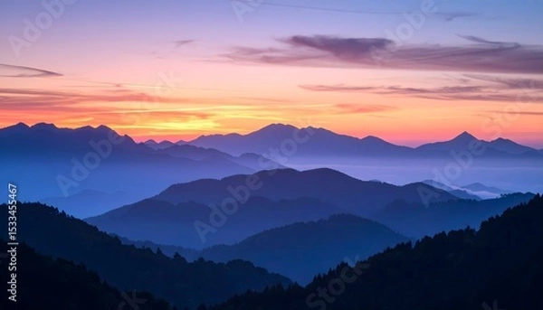Fototapeta Mountainous landscape with vibrant sunset and layered blue ridges