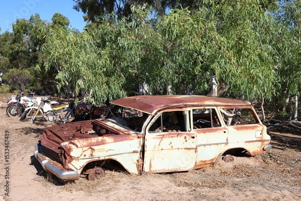 Fototapeta Vintage, old, rusty car abandoned in remote Australian Outback, amongst Eucalyptus trees. History, nostalgia, scrap, collection, travel and tourism
