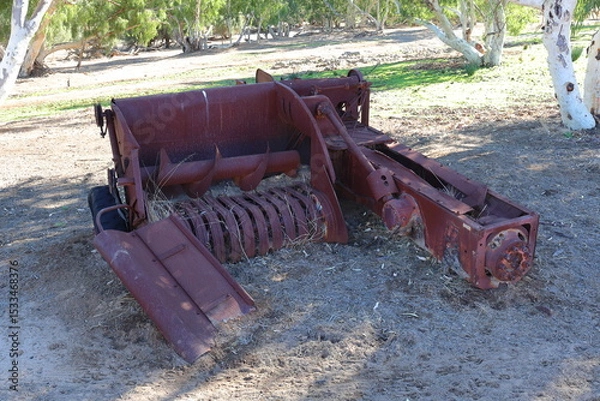 Fototapeta Vintage, old, rusty agriculture, farming equipment abandoned in remote Australian Outback, amongst Eucalyptus trees. History, nostalgia, scrap, collection, travel and tourism