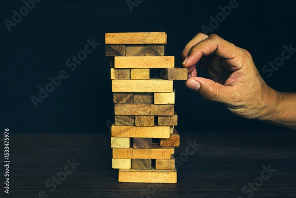 Fototapeta Close-up hand prevents and choose wooden block not falling concepts of financial risk management and strategic planning and business challenge plan or safety insurance.