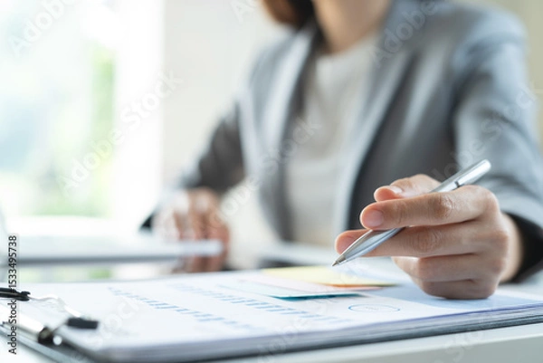 Obraz Closeup, businesswoman working at office. Business woman analyzing financial report with business document on table, marketing research and planning