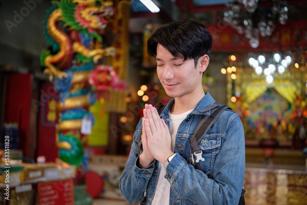 Obraz Respectful tourist exploring a traditional religious shrine during a cultural trip.