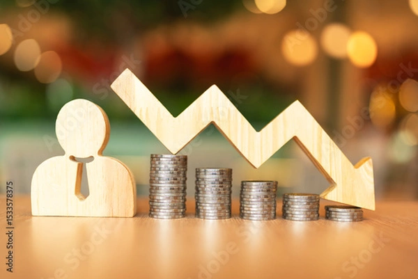 Fototapeta Employee model, centered with a downward-pointing and coin stack. This symbolizes the global economic downturn and the resulting need for organizational downsizing, wage cuts or employee layoffs.	