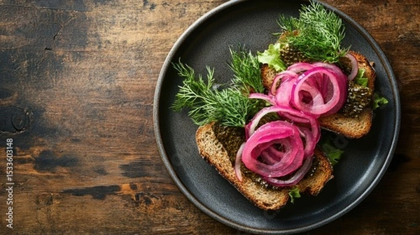 Fototapeta Minimal top-down shot of herring sandwich with rye bread, pickled onions, and fresh dill garnish