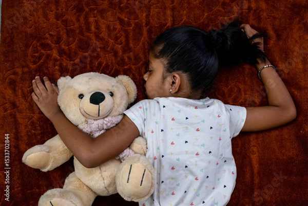 Obraz Child peacefully sleeping with teddy bear in cozy setting